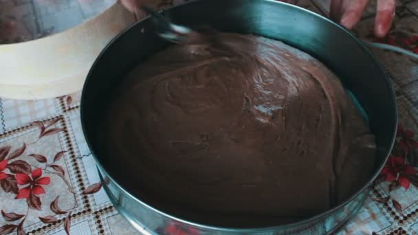 Mujer pone una masa de chocolate en un plato para hornear — Vídeo de stock