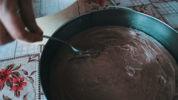 Mujer pone una masa de chocolate en un plato para hornear — Vídeo de stock