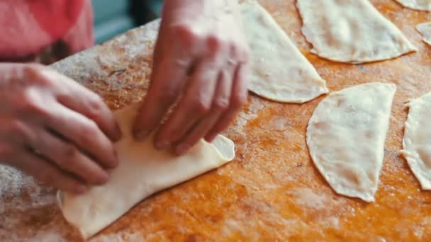 Женщина готовит мясные пироги, работает с тестом и начинкой, крупным планом — стоковое видео