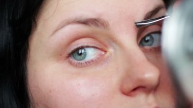 Kaşlarını yolan kadın cımbızla tükendi.