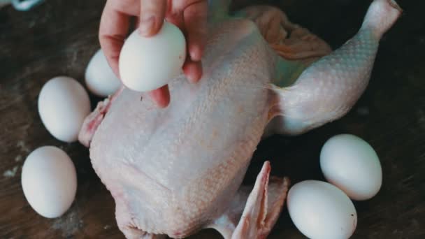 Hands preparing whole raw chicken on a wooden cooking board — Stock Video