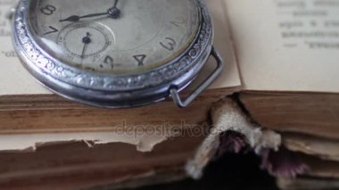 Vintage cep saati yanındaki eski soluk kitap,