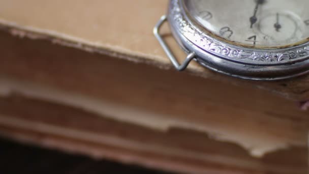 Вінтажний старовинний кишеньковий годинник на тлі старих книг — стокове відео
