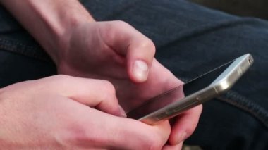 Genç oyun üstünde hareket eden telefon, ekrana bakarak adam