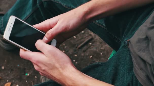 Man spelar på mobiltelefon, tittar på skärmen. — Stockvideo