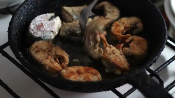 Egy serpenyőben sült hal van kapcsolva, egy villával — Stock videók