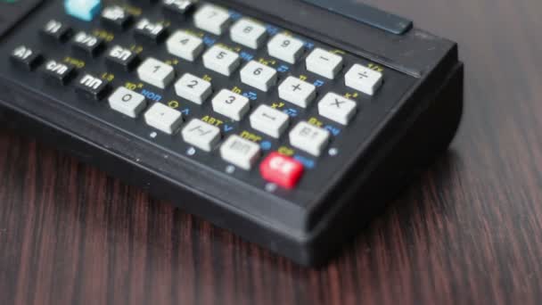 Рука управляет старым ретро калькулятором на рабочей станции — стоковое видео