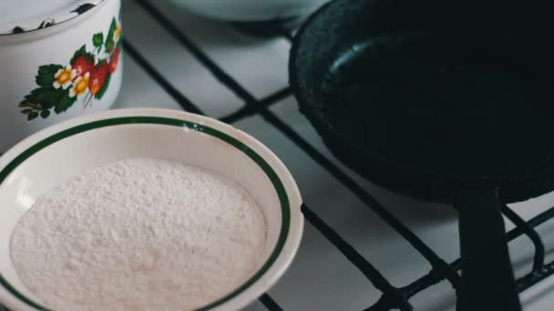 A woman wraps a piece of fresh fish in flour and puts it in a frying pan — Stock Video