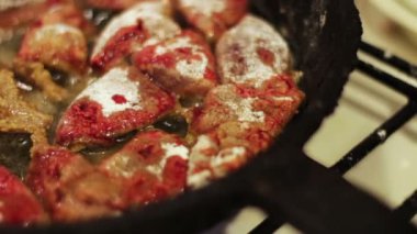 Kanlı bir ev mutfak bir tavada kızartılmış hafif karaciğer parçalarını