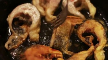 Tatlı su balık bir dökme demir tavada kızartma parçaları.