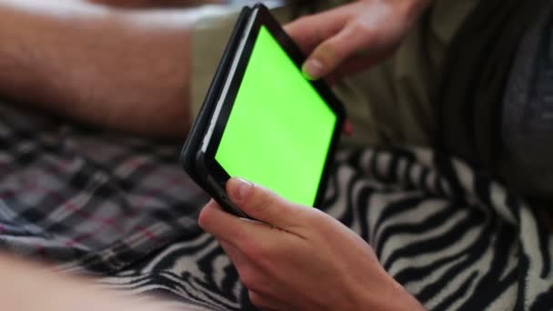 Muž drží prázdné tablet Pc s zeleným plátnem na pohovce — Stock video