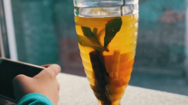 Limonlu çay tarçın ile yanındaki bir kafede bir smartphone oynamak bir çocuk