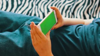Genç ile Smartphone chroma anahtar sörf Internet üzerinde evde kanepede