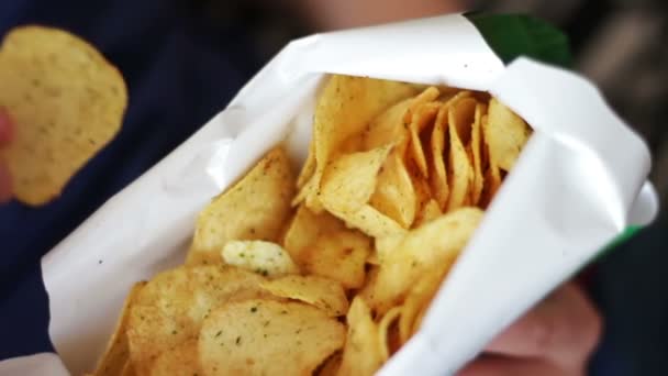 Niño adolescente comiendo papas fritas con las manos en el sofá en casa comida poco saludable — Vídeos de Stock