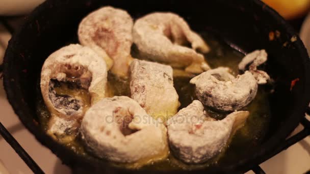 Stukken van zoetwater vis frituren in een gietijzeren koekepan. — Stockvideo