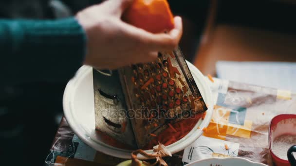 Las hembras frotan las zanahorias al rallador sobre la tabla de cortar — Vídeos de Stock