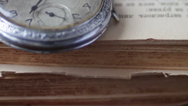 Винтажные антикварные карманные часы на фоне старых книг — стоковое видео