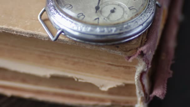 Reloj de bolsillo vintage junto al viejo libro descolorido , — Vídeo de stock