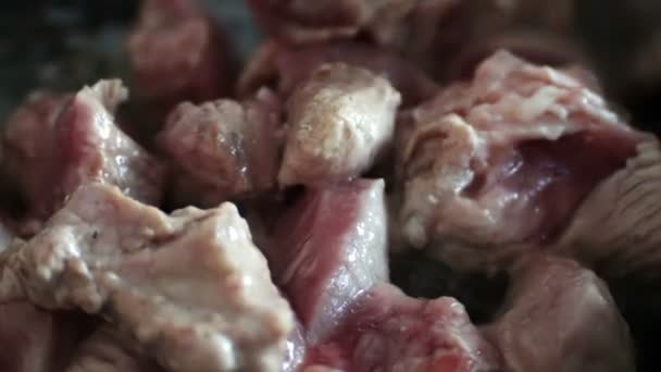 Slow motion shot of a meat cooking in the frying pan. Man is stirring it with a turner. — Stock Video