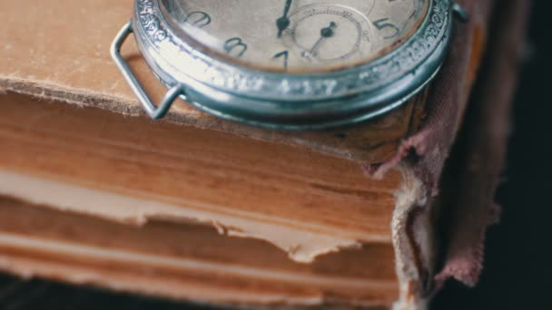 Alte antike Taschenuhr auf dem Hintergrund alter Bücher. — Stockvideo