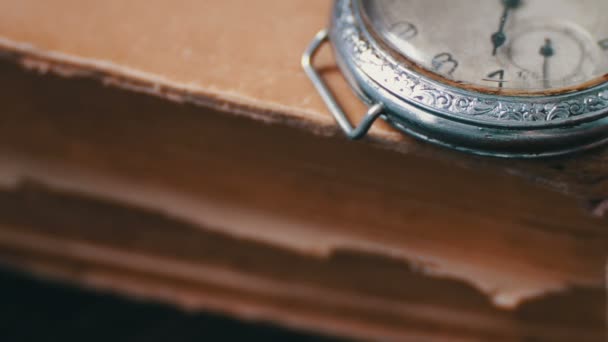 Вінтажний старовинний кишеньковий годинник на тлі старих книг . — стокове відео