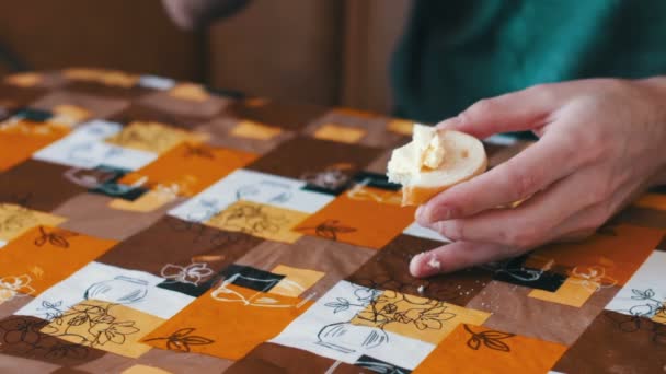 Mann verteilt Butter auf einem Brot neben einer Tasse heißen Kaffees — Stockvideo