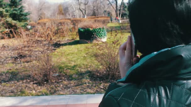 Frau benutzt Smartphone im Stadtpark — Stockvideo