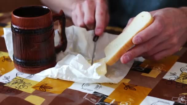 Człowiek jest szerzenie masło na chleb obok filiżankę gorącej kawy time-lapse — Wideo stockowe