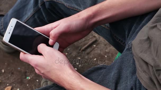 Jovem Jogando no celular, olhando para a tela — Vídeo de Stock