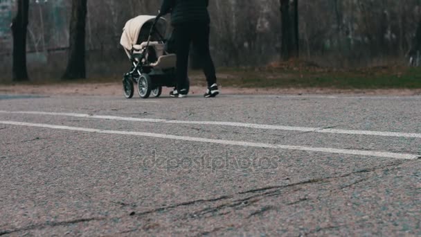 Joven madre con un paseo blanco.pies caminando sobre el pavimento . — Vídeos de Stock