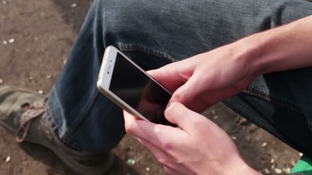 Young man Playing on mobile phone, looking at screen — Stock Video