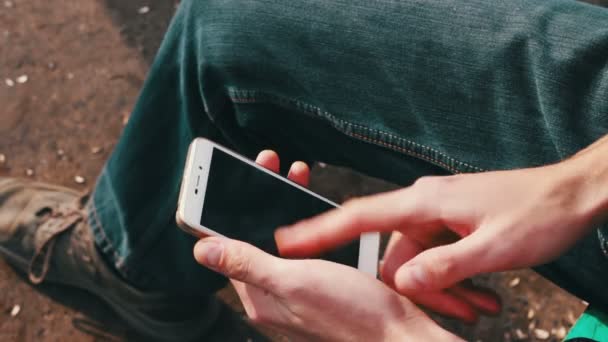 Muž si hraje na mobilním telefonu, při pohledu na obrazovku. — Stock video