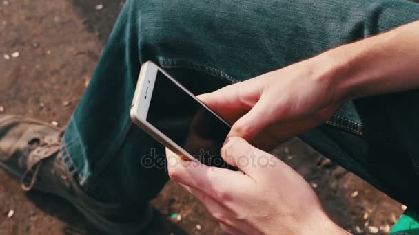 Mężczyzna gra na telefon komórkowy, patrząc na ekran. — Wideo stockowe