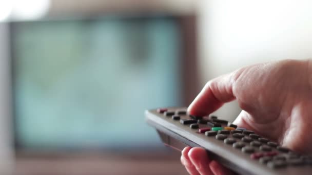 Menschliche Hand wechselt die Kanäle auf der Fernbedienung des Fernsehers — Stockvideo