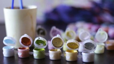 bir bardak su ve fırçalar yakın kavanozlara Akrilik boyalar