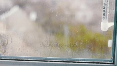 Damla akış aşağı cam üstünde belgili tanımlık pencere yağmur. Pencerenin dışındaki sıcaklık gösterir termometre