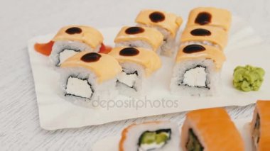 Somon, peynir, wasabi, pembe zencefil, soya sosu şık beyaz ahşap zemin üzerinde ile lezzetli suşi