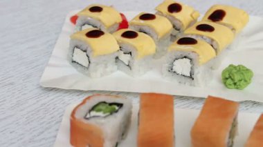 Somon zencefil ve peynir ve wasabi bir kafede beyaz plakaları ile taze lezzetli suşi