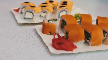 Somon, peynir, wasabi, pembe zencefil, soya sosu şık beyaz ahşap zemin üzerinde ile lezzetli suşi