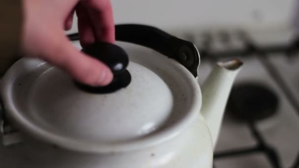 Vintage white teapot stands on a stove and boils — Stock Video