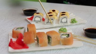 Suşi Çin sopa ile alınan ve soya sosuna batırılmış. Somon ile lezzetli suşi zencefil peynir ve wasabi