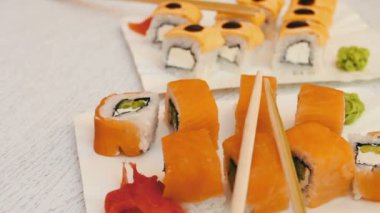 Somon, peynir, wasabi, pembe zencefil, soya sosu şık beyaz ahşap zemin üzerinde ile lezzetli suşi