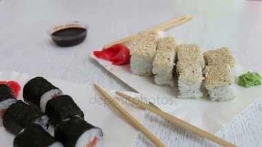 Somon ve balık, pembe zencefil, bir plaka üzerinde yeşil wasabi ve soya sosu güzel şık beyaz arka plan üzerinde suşi ile lezzetli suşi maki