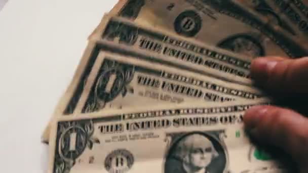 Vrouw countslot van kleine dollarbiljetten op tafel met een witte achtergrond macro close-up — Stockvideo