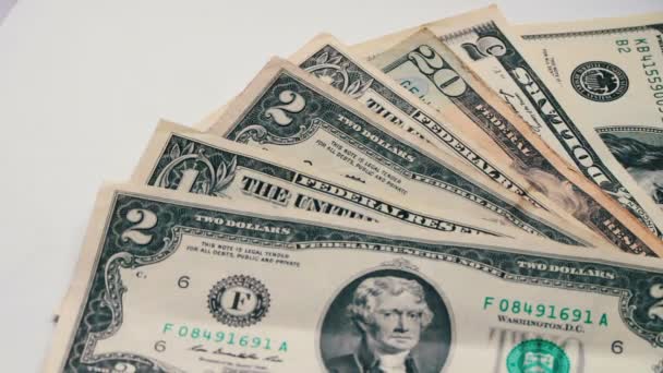 Mulher contagens de pequenas notas de dólar na mesa com um fundo branco macro close-up — Vídeo de Stock
