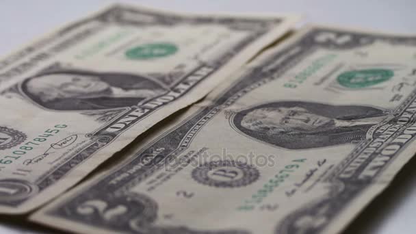 Wiele małych Dolar rachunki upadek na stole z makro na białym tle z bliska — Wideo stockowe