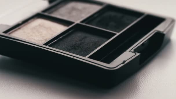 Gray shades of eyeshadow,Close up of makeup brush moving over eye shadows — Stock Video