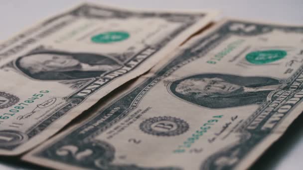 Sok kis dollár számlák esik az asztalra, egy fehér háttér makró közelről — Stock videók