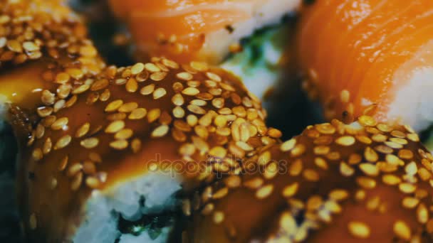 Rotolo di maki al salmone. Cucina giapponese con sushi e pesce crudo fresco.Piatto giapponese composto da riso, salmone o tonno, gamberetti e uova di pesce imbevute di soia — Video Stock