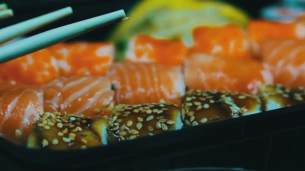 Japanse sushi gerechten met verse rauwe vis. Japanse schotel bestaande uit rijst, zalm of tonijn, garnalen en vis eieren gedrenkt in soja — Stockvideo